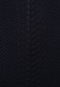 Tejido de punto con un patrón texturizado que recuerda cuerdas trenzadas, en un color azul marino oscuro, que muestra profundidad y suavidad.