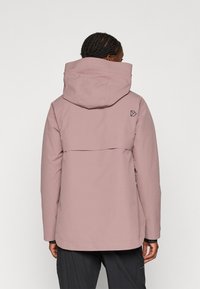 Roze waterdichte jas met een grote capuchon, voorzien van een achterventilatie en een logo-detail. Glad textuur met een ontspannen pasvorm ontwerp.