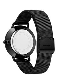 Montre noire en acier inoxydable avec un boîtier rond lisse, un bracelet en maille et des détails argentés à l'arrière. Elle dispose d'un fermoir sécurisé et d'une résistance à l'eau.