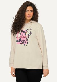 Felpa beige con un design a stampa leopardata rosa e testo "REAL LOVE". Presenta occhielli in metallo e una vestibilità comoda con maniche lunghe.