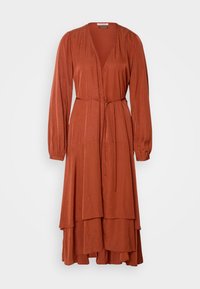 Robe midi à manches longues de couleur rouille avec décolleté en V, lien à la taille enroulé, jupe superposée et texture à petits points subtile sur le tissu.