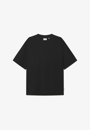 Melnā oversized T-krekls no kokvilnas ar apaļu izgriezumu un īsām piedurknēm. Gluda tekstūra bez redzamām rakstam vai akcents.