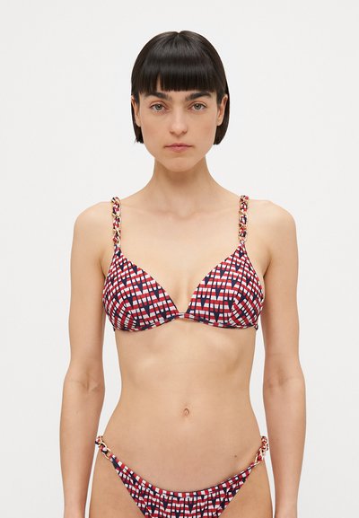 Trójkątny bikini w czerwono-biało-niebieski geometryczny wzór. Posiada plecione ramiączka z złotymi akcentami po bokach dolnej części.