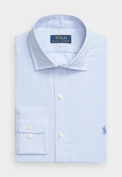 Chemise à rayures bleu clair en coton. Présente un col pointu, des poignets à bouton et un petit logo brodé sur la poitrine.