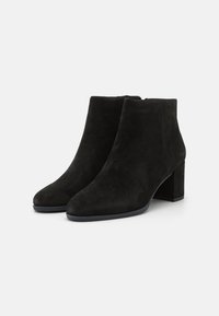 Schwarze Wildleder-Stiefeletten mit spitzem Zehenbereich und blockigem Absatz. Bieten eine glatte Textur und minimale Nahtdetails.