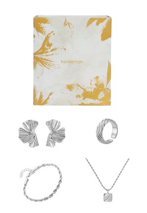 Ensemble de bijoux en argent comprenant des boucles d'oreilles en forme de fleur, une bague torsadée, un bracelet tressé et un collier avec un pendentif carré texturé, le tout dans une boîte décorative.