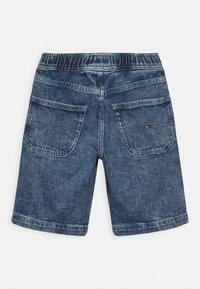 Niebieskie szorty dżinsowe z elastycznym pasem, wyposażone w dwie tylne kieszenie oraz małą metkę z logo przy prawej kieszeni.