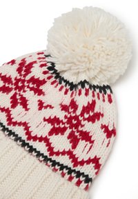 Cappello invernale lavorato a maglia di colore crema con motivi di fiocchi di neve rossi e una soffice pom-pom bianca sulla sommità; presenta un polsino a coste crema e dettagli neri.