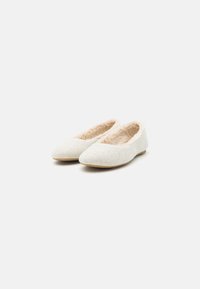 Ballerines douces et légères de couleur beige clair avec un bout rond, fabriquées en feutre, dotées d'une doublure intérieure douce et d'une semelle fine et flexible.