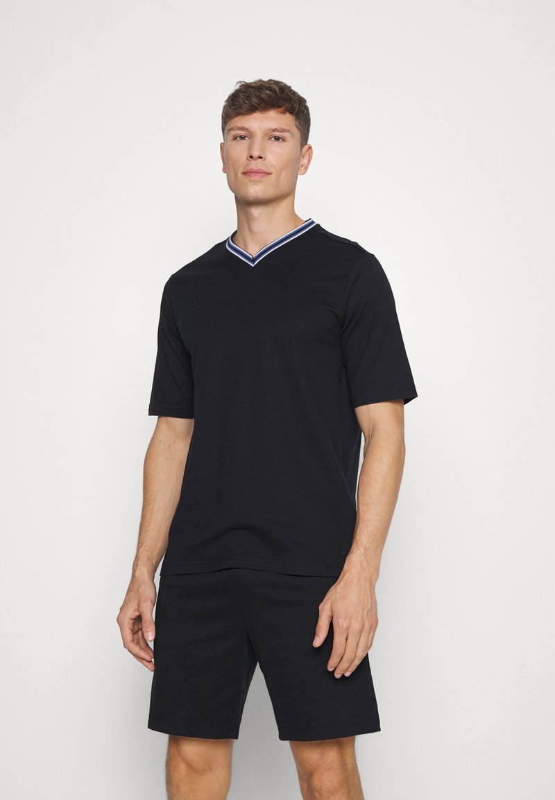 Sort T-shirt med korte ærmer og V-hals, med en krave i blå og hvid stribe. Sammen med matchende sorte shorts.