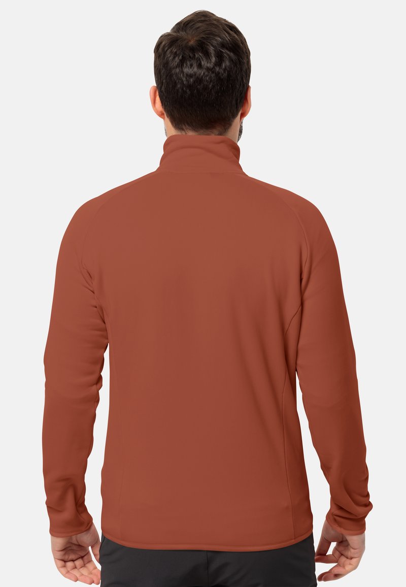Rustfarbener Fleece-Jacke mit hohem Kragen, langen Ärmeln und einer glatten, weichen Textur. Keine sichtbaren Muster oder Beschläge.