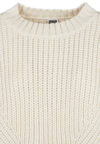 Pull en maille écru avec une texture côtelée et un col rond. Le tissu semble doux et légèrement épais.