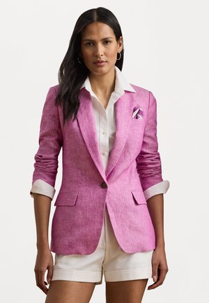 Pink linen blazer with notched lapels, two front pockets, and a single button closure. Paired with a white shirt and cream shorts.