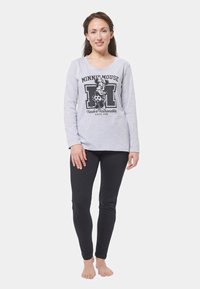 Maglione grigio a maniche lunghe con una grafica nera di Minnie Mouse e testo, abbinato a leggings neri aderenti, entrambi progettati per l'abbigliamento casual.