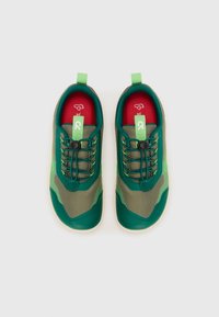 Zapatillas deportivas verdes y grises con parte superior de malla, suela de goma, cordones redondos y un tirador en el talón para facilitar el calzado.