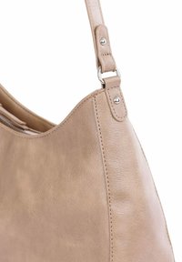 Světlá kožená taška s hladkým povrchem, zakřiveným tvarem a nastavitelným popruhem. Obsahuje kovové prvky a zip na horní části.