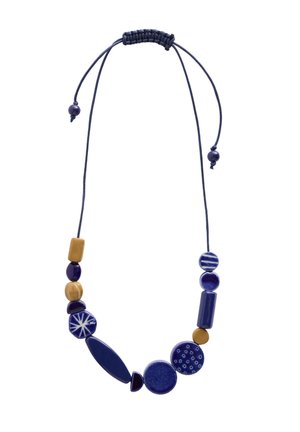 Collier à cordon bleu marine ajustable avec des perles géométriques bleues et beiges assorties, certaines avec des motifs, disposées dans des formes et tailles variées.