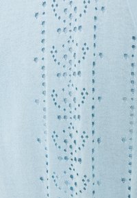 Maglione lavorato a maglia di colore azzurro chiaro, caratterizzato da intricati motivi ad openwork, con una consistenza morbida e una vestibilità rilassata.