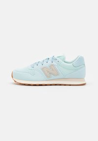 Light blue athletic shoe with a suede and mesh upper, featuring a beige logo, round laces, and a rubber sole with a textured pattern.