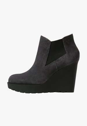 Bottines à talons compensés en suède gris avec un embout arrondi, des panneaux latéraux élastiques et une semelle en caoutchouc noir texturé. Fini lisse avec un aspect mat.