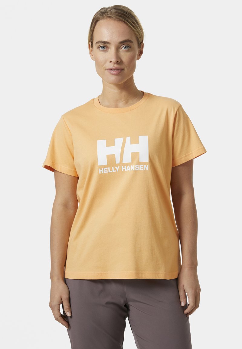 Camiseta de algodón naranja con mangas cortas, escote redondo, que presenta un gran logo blanco de "HELly HANSEN" en el frente. Corte estándar.