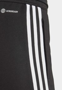 Schwarze Trainingshosen mit drei weißen vertikalen Streifen, AEROREADY-Logo und einer zippered Tasche an der Seite. Glatte Textur und enganliegendes Design.