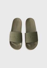 Oliivivihreät liukumäkipohjalliset sandaalit, joissa on teksturoitu hihna. Mukana kohokuvioitu "HILFIGER"-logo. Pehmeä, muotoiltu pohja mukavuutta varten.