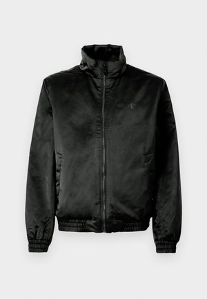 Black bomber jacket made of smooth, shiny fabric with a high collar, zip front, and elasticized cuffs and hem. Minimal branding on chest.