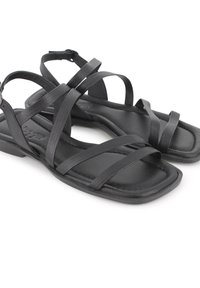 Sandalias planas negras con múltiples tiras delgadas, punta cuadrada y plantilla texturizada. Material duradero y diseño minimalista.