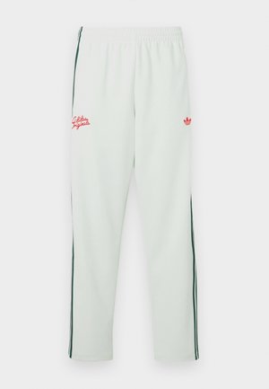 Pantalones deportivos verde claro con cintura elástica, con logotipo bordado rojo y franjas laterales verdes. Tejido suave con un corte holgado.