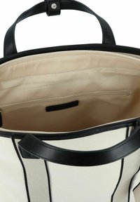 Borsa tote in tela con dettagli in pelle nera, caratterizzata da un interno beige, tasca con zip e due manici. Design a strisce nere sull'esterno.