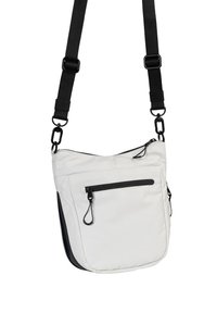 Crossbody tas van witte stof met een zwart ritsvak en zwarte afwerking. Voorzien van verstelbare zwarte banden en metalen hardware accenten.
