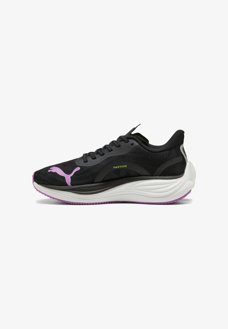Sorte atletiske sko med en teksturert overdel, med en rosa Puma-logo, neonlys detaljer og en tykk hvit såle med en lilla bunn.