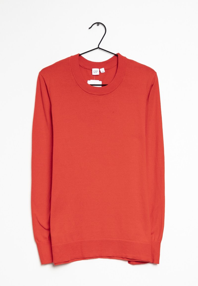 Pull rouge à manches longues en tissu tricoté, avec un col rond et un ourlet côtelé. Suspendu à un crochet noir avec des étiquettes attachées.