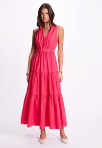 Rosa, ärmelloses Maxikleid mit tailliertem Design, gestuftem Schnitt und fließendem Stoff. Die strukturierte Oberfläche verleiht der einfarbigen Optik zusätzliche Raffinesse.