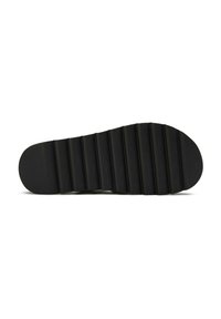 Black shoe sole with ridged patterns, elongated shape, made from rubber or similar material, featuring a smooth, matte finish.