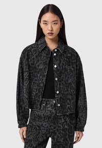 Μαύρο τζιν μπουφάν με λεοπάρ σχέδιο, ασημένια κουμπιά, γιακά και πλαϊνές τσέπες, συνδυασμένο με παντελόνι ψηλόμεσο με το ίδιο σχέδιο.