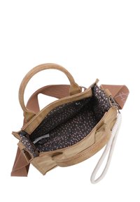 Bolso de ante color beige con un acabado texturizado, que presenta una correa de tela marrón, un interior con un patrón de puntos en negro y rosa, y un bolsillo con cremallera.