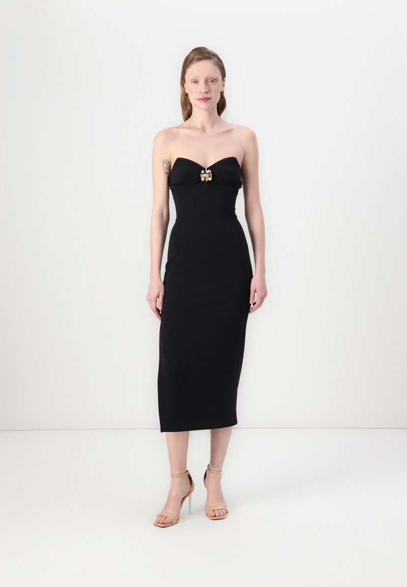 Čierne strapless šaty s priliehavým strihom, nariasenou tkaninou na poprsí a zlatým dekoratívnym sponou, siahajúcimi po stred lýtok.