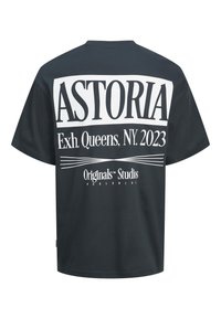 Juoda marškinėliai su dideliu baltu tekstu ant nugaros, skaitančiu "ASTORIA Exh. Queens, NY. 2023" ir "Originals™ Studios Worldwide."