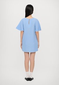 Hellblaues Kleid mit kurzen, gewellten Ärmeln und einem Schlüsselloch-Detail im Rücken. Es hat einen gewellten Saum und eine lässige Passform.