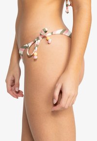 Bikiniunderdel i randig tyg med rosa, gröna och vita nyanser. Har knytningar med färgade pärlor som framhäver en texturerad yta.