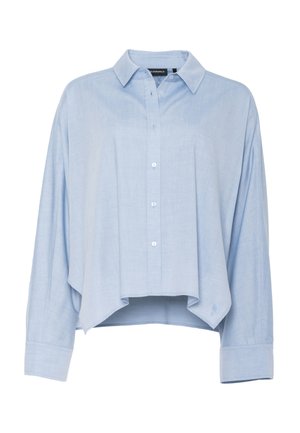 Vaaleansininen pitkähihainen nappikauluspaita, jossa on terävä kaulus, epäsymmetrinen helma ja leveät kalvosimet.