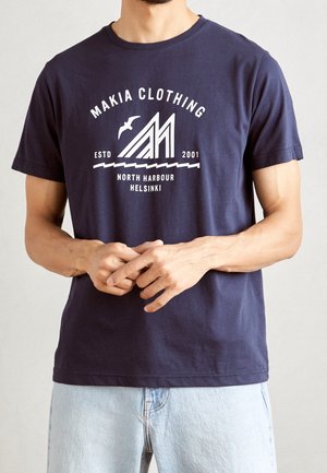 T-shirt en coton bleu marine avec un col rond, arborant un texte graphique blanc et un design de montagne. Manches courtes, coupe standard, ourlet uni.