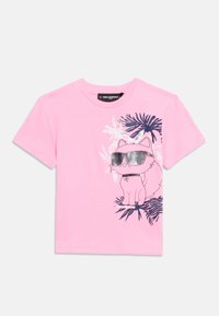 Ροζ κοντομάνικη μπλούζα με κινούμενη εικόνα μιας γάτας που φορά γυαλιά ηλίου, καθισμένη ανάμεσα σε αφηρημένα ασπρόμαυρα τροπικά φύλλα.