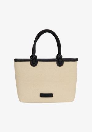 Beige stoffen draagtas met zwarte leren accenten, voorzien van twee handgrepen, een gestructureerde vorm en een klein zwart label aan de onderkant.