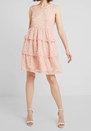 Růžové šaty bez rukávů s květinovým potiskem, véčkovým výstřihem a krajkovým lemováním. Vyrobené z lehké tkaniny, mají tři vrstvy volánů.
