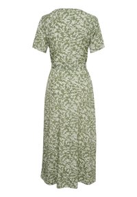 Abito floreale verde con maniche corte, vita aderente e gonna svasata. Presenta un motivo di foglie e fiori bianchi sul tessuto.