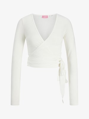 Balta, garām piedurknēm, ar dziļu V-veida izgriezumu un sānu sasiešanas detaļu. Mīksts, pieguļošs audums un īss garums.