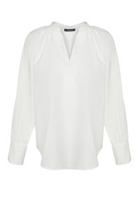 Blouse blanche à manches longues avec col en V froncé et larges poignets, confectionnée dans un tissu léger.